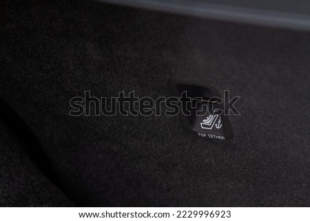 Sign on black leather seat. IClamping for child car seats.