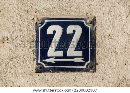 Weathered grunge square metal enameled plate of number of street address with number 22