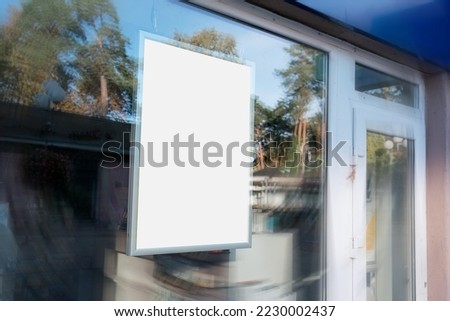 Blank vertical banner mounted behind window of urban pharmacy. Pharmaceutical concept.