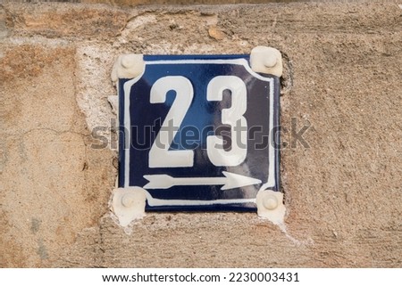 Weathered grunge square metal enameled plate of number of street address with number 23