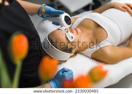 cosmetologist making photorejuvenation procedure for a client to treat skin conditions and remove spots or textures, beauty treatment concept. High quality photo