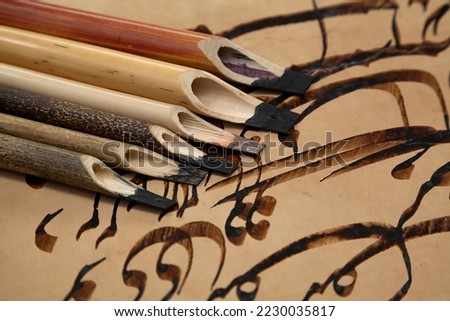 A set of calligraphy reeds. Calligraphy reeds (qalam) covered in ink against. Arabic and Persian calligraphy pen. Islamic background of tools for quran calligraphy Royalty-Free Stock Photo #2230035817