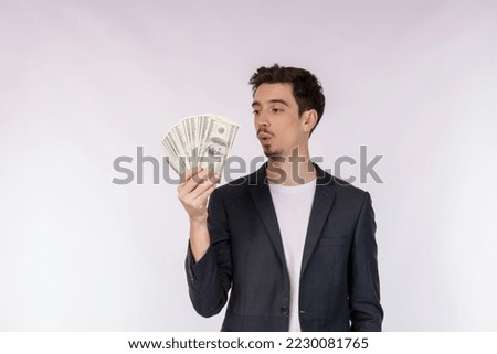 Portrait of a cheerful man holding dollar bills over white background. Finance, investment and money saving concept.