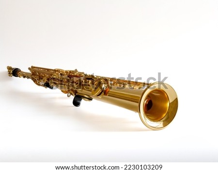 Soprano Sax, wind instrument saxophone lying on a white background, copy space. Royalty-Free Stock Photo #2230103209