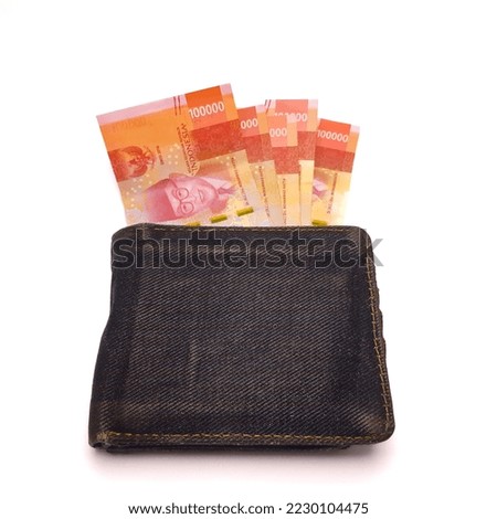 One hundred thousand rupiah money is in a black wallet, isolated background.