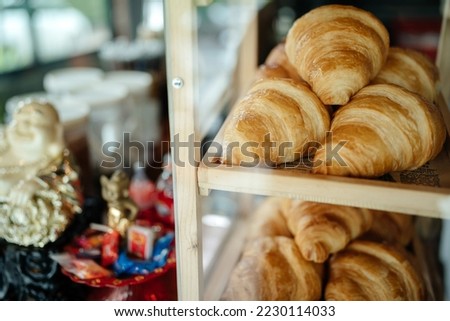 Fresh croissants lie in the window of a French cuisine store.