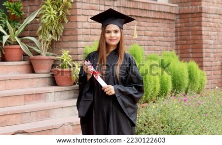 Young indian graduated girl holding his graduation degree convocation ceremony. Royalty-Free Stock Photo #2230122603