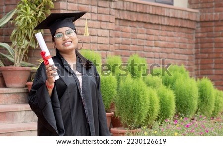 Young indian graduated girl holding graduation degree convocation ceremony. multiracial student graduate posing. Royalty-Free Stock Photo #2230126619