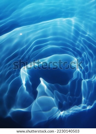 Closeup​ blur​ abstract​ of​ surface​ blue​ water. Abstract​ of​ surface​ blue​ water​ reflected​ with​ sunlight​ for​ background.Top​ view​ of blue​ water.​ Water​ splashed​ use​ for​ graphic​ design Royalty-Free Stock Photo #2230140503