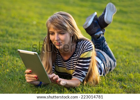 young woman using a tablet outdoors