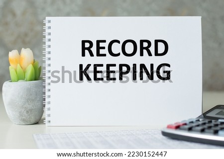 RECORD KEEPING text written on a notebook on the wooden background