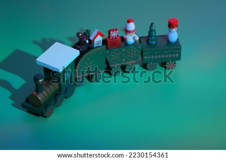Christmas wooden train with toys on a green background. Christmas toys.