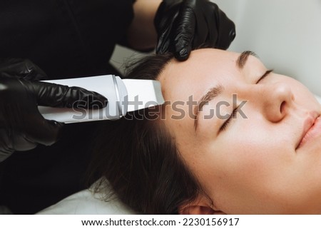 Skin care. Close-up Of A Beautiful Woman Receiving An Ultrasound Facial Peeling. Ultrasonic skin cleaning procedure. Cosmetic procedures. Cosmetology. Royalty-Free Stock Photo #2230156917