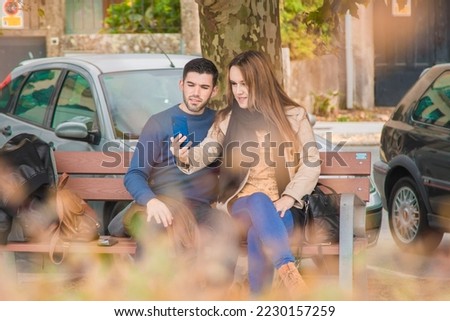 woman showing mobile phone to her partner in the street