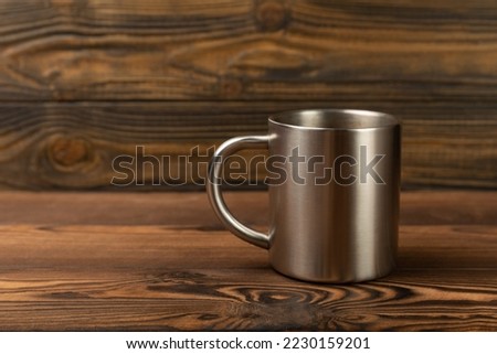 Metal travel mug on a brown background. Mug for hot drinks. place for text. copy space.