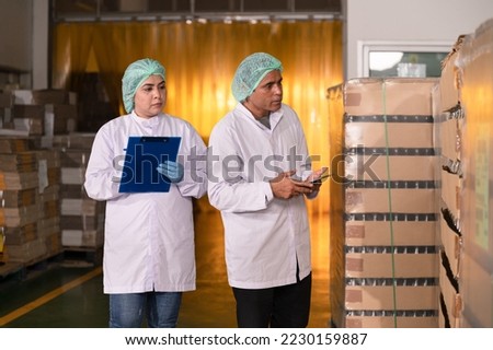 Two inspector scientists checking stock juice in glass bottle food product at food industry	