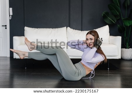 Brunette caucasian girl with artificial hand at exercise workout home in sportswear. Rehabilitation after trauma domestic leisure activities. Hispanic young woman with bionic arm practicing sport home