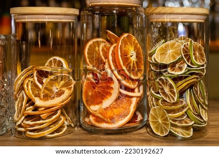 Slices of dried orange in the glass. Tree jars with dried citrus, close up image. Lime, lemon and grapefruit dried slices. Royalty-Free Stock Photo #2230192627