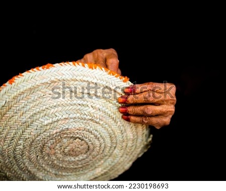 An old woman doing a handicraft to make a dining table