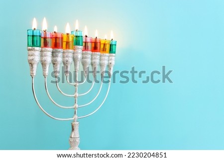 Image of jewish holiday Hanukkah with menorah (traditional candelabra) and colorful oil candles Royalty-Free Stock Photo #2230204851