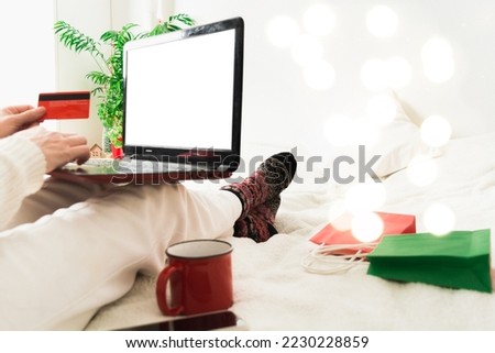 Online shopping concept with woman holding laptop and credit card at home