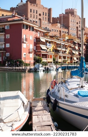 Colorful buildings with canals and yachts in the resort. Travel destination in Mediterranean. European relaxing holidays. Colored houses reflected in the water of canal with parked boats.