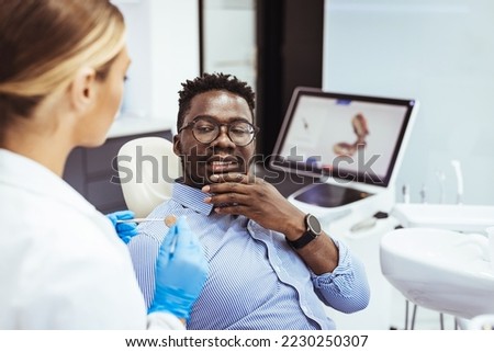 Black guy patient with open mouth having dental treatment from female doctor, close up. Man and female doctor while checkup teeth. Healthy lifestyle, healthcare and medicine concept.