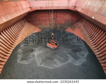 Bulk cargo is loaded or discharged from or to a cargo house of a bulk carrier Royalty-Free Stock Photo #2230261645