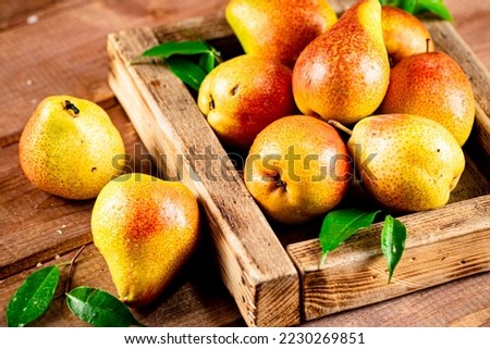 Fresh pears on a tray with leaves. On a wooden background. High quality photo