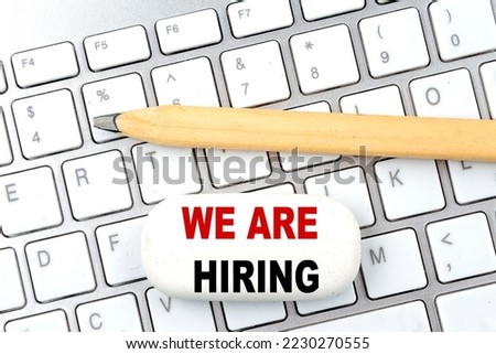 WE ARE HIRING text on a eraser with pencil on keyboard