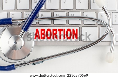 ABORTION text on a keyboard with stethoscope , medical concept