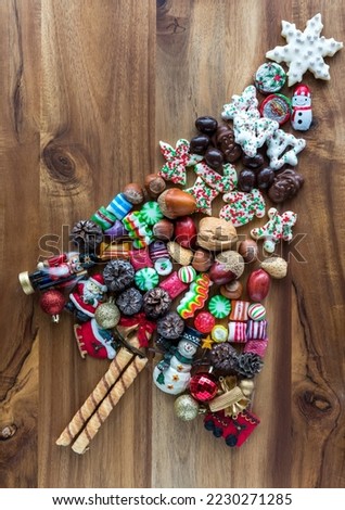 Various festive confections in the shape of a tree on a wooden board.