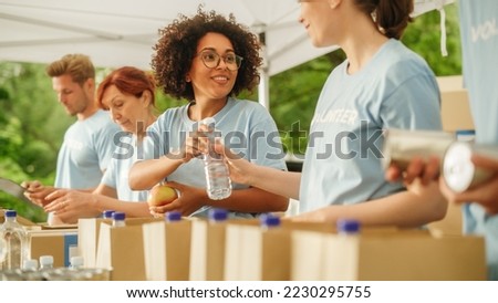 Group of Volunteers Preparing Free Food Rations for Poor People in Need. Charity Workers and Members of the Community Work Together. Concept of Giving, Humanitarian Aid and Society. Royalty-Free Stock Photo #2230295755