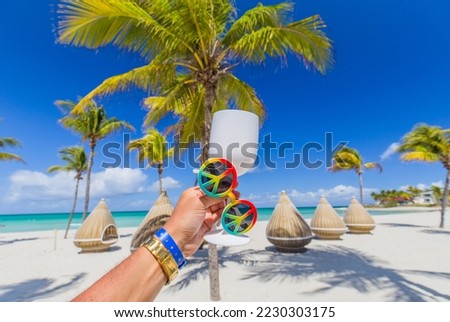 Festive drink in hand against a beautiful sea. luxury beach on a background of beauty of the sea with coral reefs. vacation at exotic resorts Bavaro, Punta Cana, Dominican Republic