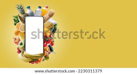 Smartphone with blank screen and fresh groceries: online grocery shopping app Royalty-Free Stock Photo #2230311379