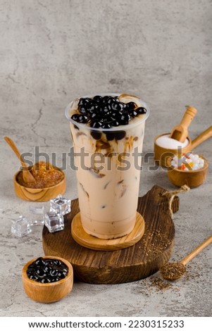 Boba or tapioca pearls is taiwan bubble milk tea in plastic cup with brown sugar flavor on texture  background, summers refreshment. Royalty-Free Stock Photo #2230315233
