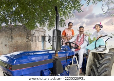 Indian rural family sitting on tractor.