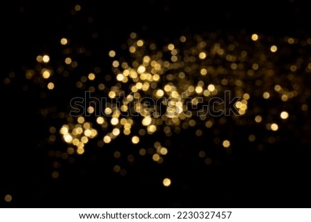 Golden blurred bokeh lights on black background. Glitter sparkle stars for celebrate. Overlay for your design Royalty-Free Stock Photo #2230327457