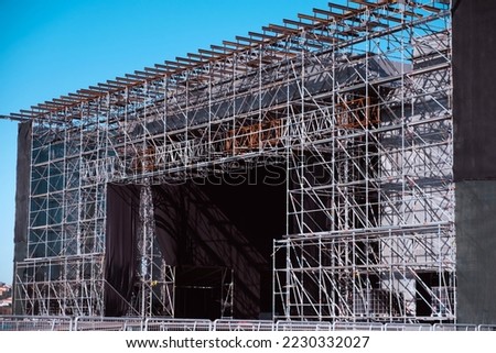 Installation of professional concert equipment. Lifting of line array speakers. Truss with spot lighting equipment above the stage.