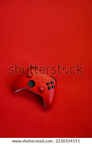 Gamepad on a red background. Game concept, esports, leisure, gaming industry, video games. Flat lay, top view