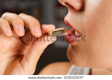 Girl is taking capsule of collagen supplement. Collagen pills to support skin health. BADS biologically active dietary supplements for healthcare Royalty-Free Stock Photo #2230350597