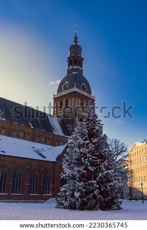 A beautiful Christmas card with a medieval church and a snow-covered city fir