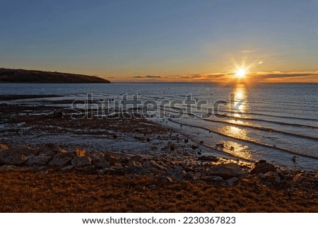 Sunrise over tje St-Lawrence river waters in La Malbaie, Quebec Royalty-Free Stock Photo #2230367823
