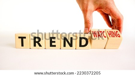 Trend or trendwatching symbol. Concept words Trend and trendwatching on wooden cubes. Businessman hand. Beautiful white table white background. Business trend or trendwatching concept. Copy space.