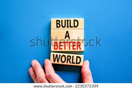 Build a better world symbol. Concept words Build a better world on wooden cubes. Beautiful blue table blue background. Businessman hand. Business build a better world concept. Copy space. Royalty-Free Stock Photo #2230372309