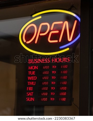 Open business hours sign on restaurant door
