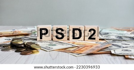 PSD2 inscription on the texture of wooden cubes. Wooden cubes on the background of banknotes. An inscription on a financial, business or economic theme.