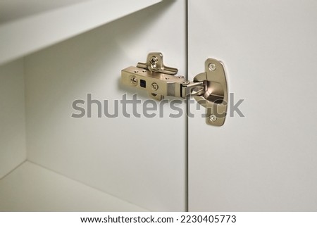 Hinge cabinet of kitchen cupboard door metal furniture isolated on white background, hardware on wood with copyspace. Royalty-Free Stock Photo #2230405773