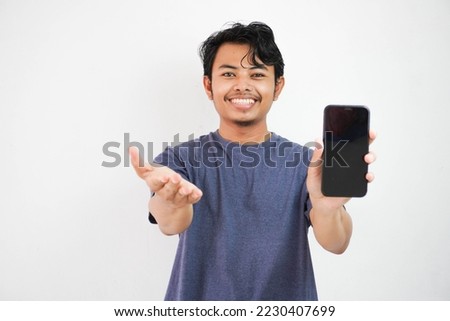 Happy smiling Asian young man showing mobile phone in other hand open isolated on white background