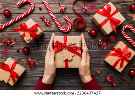 Woman hands holding gift box, preparing surprise for holiday, top view, Christmas and New Year concept.